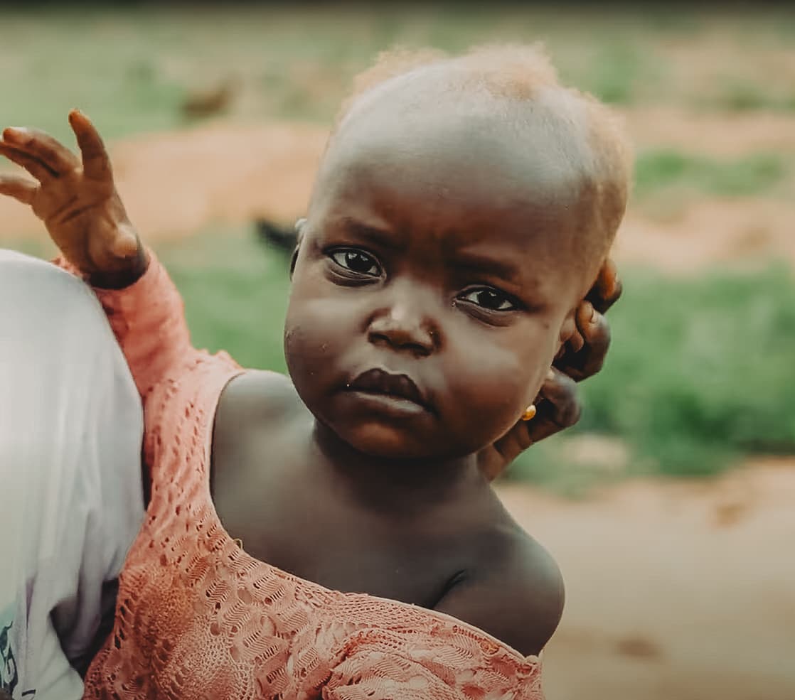 An elderly caregiver washing a young child's hands