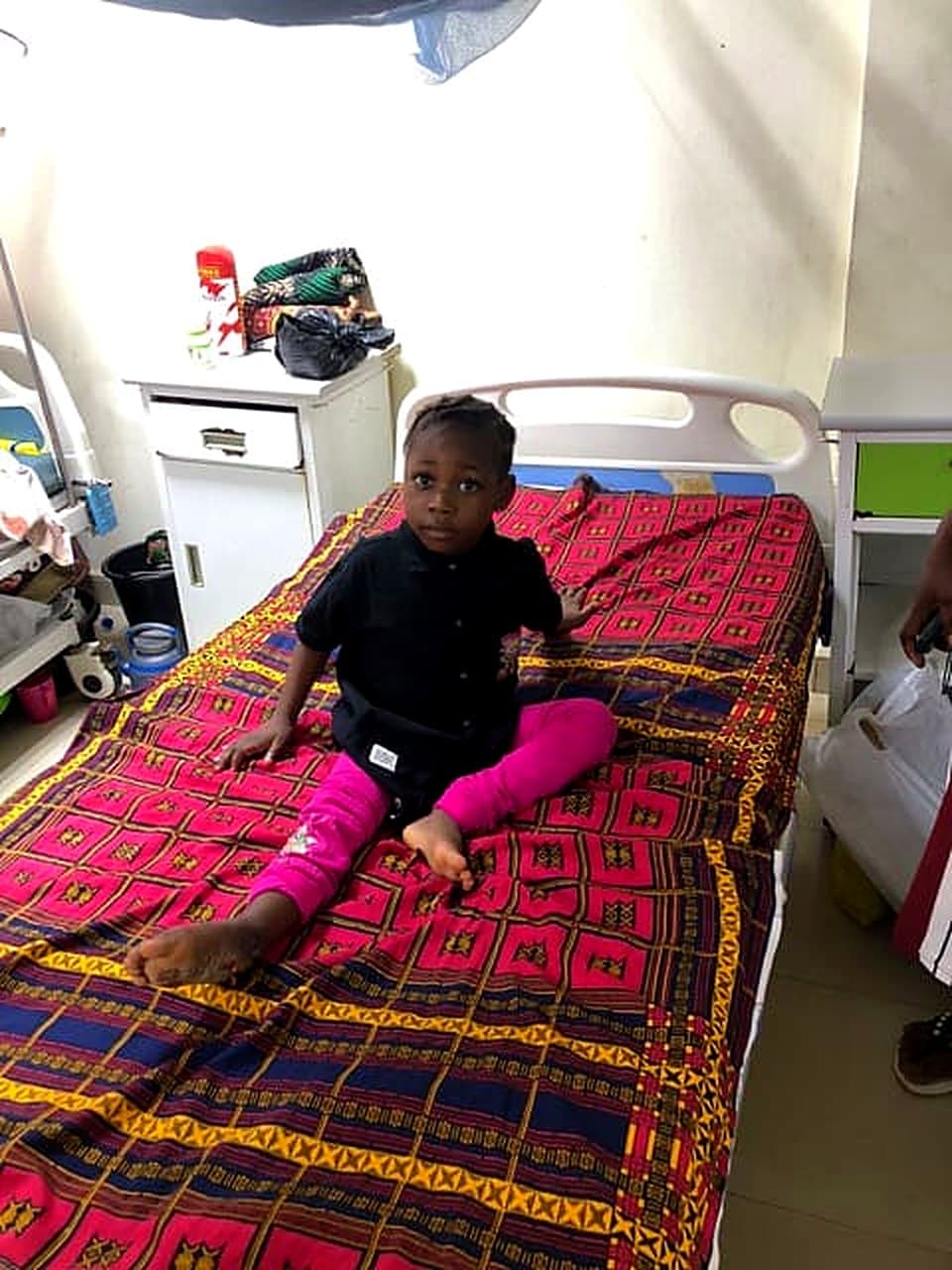 Six-year-old Success sitting on her hospital bed